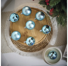 Dekorative Szene mit blauen Weihnachtskugeln auf einem Holzteller und einem geflochtenen Untersetzer