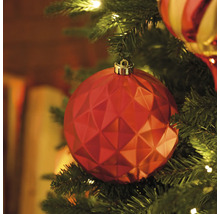 Nahaufnahme eines roten, facettierten Weihnachtsbaumschmuckes an einem Weihnachtsbaum
