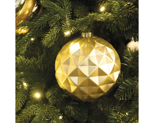 Goldene Weihnachtskugel mit geometrischem Muster am Weihnachtsbaum