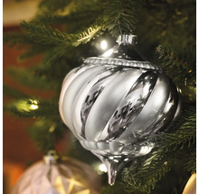 Silberfarbener, gewirbelter Christbaumschmuck an einem Weihnachtsbaum