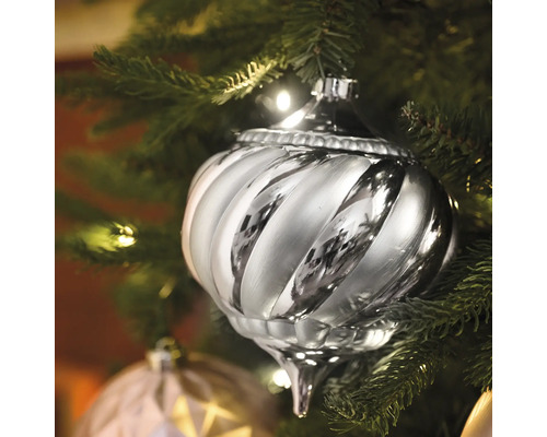 Silberfarbener, gewirbelter Christbaumschmuck an einem Weihnachtsbaum