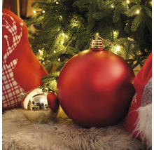 Weihnachtsdekoration mit Christbaumkugeln und Dekokissen unter einem Weihnachtsbaum