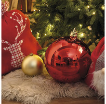 Dekorative Weihnachtsszene mit Christbaumkugeln, Geschenkesack und Lichterkette unter einem Weihnachtsbaum