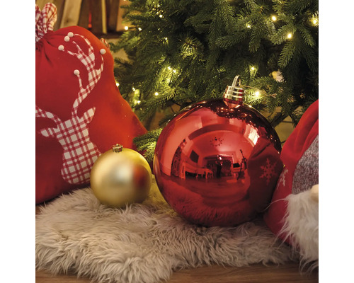 Dekorative Weihnachtsszene mit Christbaumkugeln, Geschenkesack und Lichterkette unter einem Weihnachtsbaum
