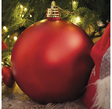 Große rote Christbaumkugel unter einem Weihnachtsbaum