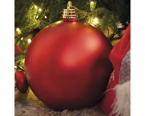 Große rote Christbaumkugel unter einem Weihnachtsbaum