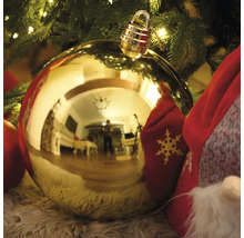 Goldene Christbaumkugel mit Aufhänger vor Weihnachtsbaum