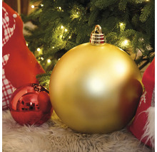 Goldfarbene und rote Christbaumkugeln unter einem Christbaum