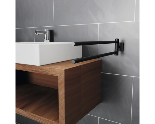 Waschbecken mit Armatur auf Holzunterschrank und schwenkbarer Handtuchhalter an grauer Wand