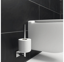 Detailaufnahme einer Toilette mit Toilettenpapierhalter an der Wand.