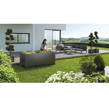 Gartenszene mit Hochbeet, Sitzgruppe und dekorativen Pflanzenkübeln auf Terrasse und Rasen