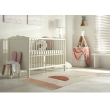 Kinderzimmer mit Gitterbett, Stuhl mit Hasenohren und Teppich mit geometrischen Formen.