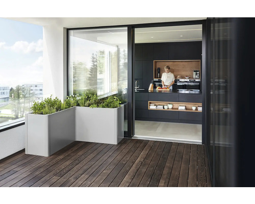 Balkon mit Kräutergarten in Pflanzkästen und Blick in eine Küche