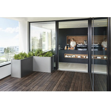 Balkon mit grauen Pflanzkästen und Blick in eine Küche mit schwarzer Küchenzeile