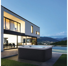 Whirlpool neben modernem Haus mit Pool und Bergblick.