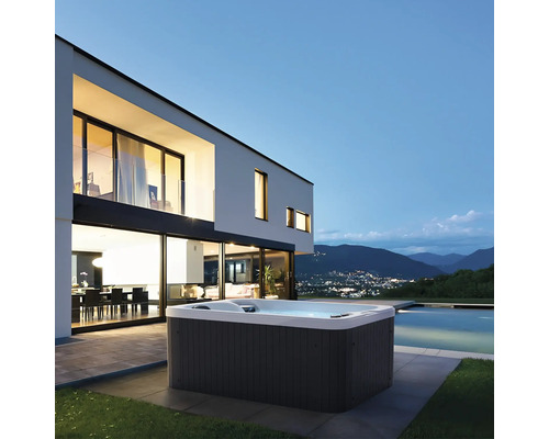 Whirlpool neben modernem Haus mit Pool und Bergblick.