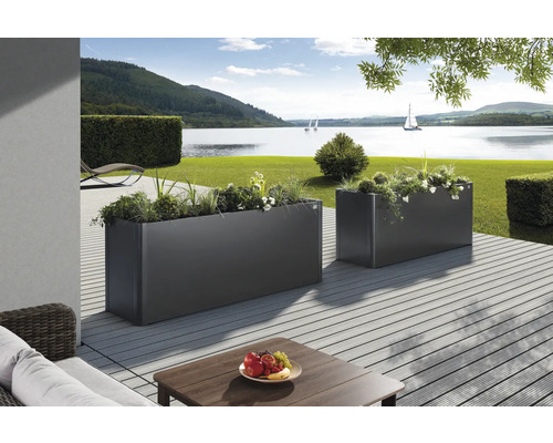 Zwei bepflanzte, rechteckige Pflanzkästen auf einer Terrasse mit Seeblick
