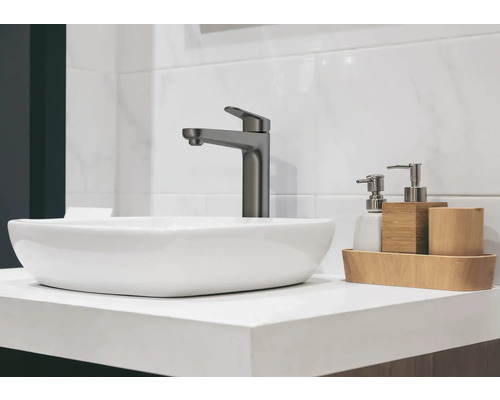 Waschbecken mit Armatur und Badaccessoires auf einer Ablage
