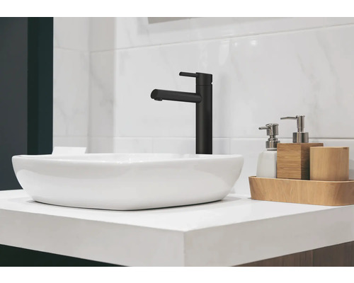 Modernes Badezimmerwaschbecken mit schwarzem Wasserhahn und Seifenspender auf einer hellen Arbeitsplatte