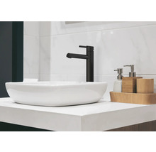 Waschbecken mit schwarzem Wasserhahn und Badaccessoires auf einem Waschtisch