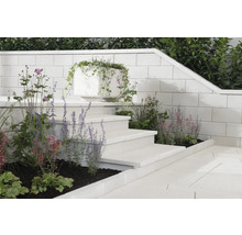 Garten mit Steinstufen, Mauer und bepflanztem Pflanzkübel