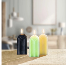 Drei dekorative Kerzen mit Bogenmuster stehen auf einem Tisch.