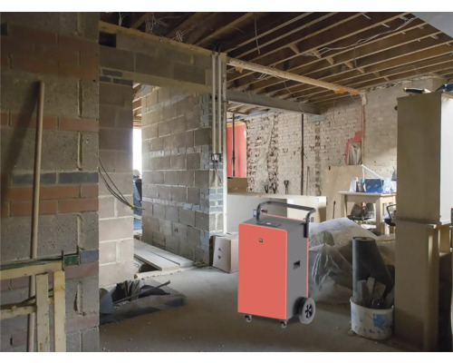 Entfeuchter in einem unfertigen Raum mit Ziegelwänden und freiliegenden Deckenbalken.