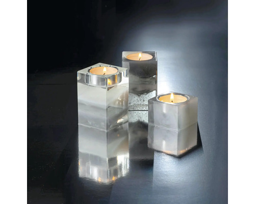 Drei Teelichthalter aus transparentem Material mit Teelichtern