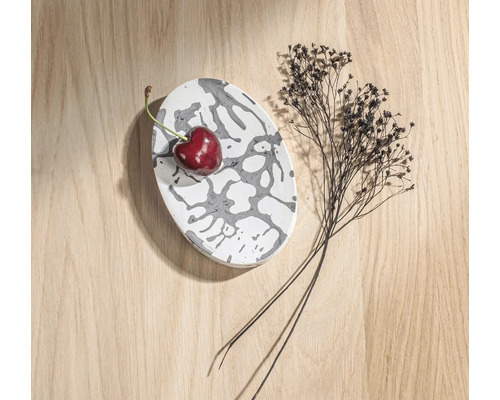 Dekorative ovale Schale mit Muster, Kirsche und Trockenblumen auf Holztisch