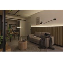 Wohnzimmer mit Sofa, Holzwandpaneelen, Leuchte und Esstisch