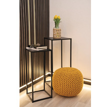 Dekorative Inneneinrichtung mit zwei Beistelltischen, einem Strickhocker und einer Vase mit Tulpen