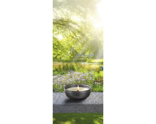 Kerze in einer Schale vor einem Gartenhintergrund