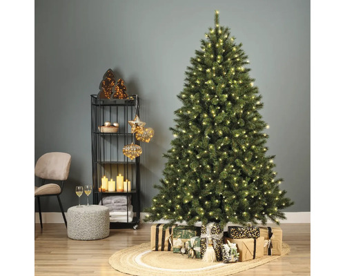 Weihnachtsbaum mit Beleuchtung und Geschenken in einem festlich dekorierten Wohnzimmer.