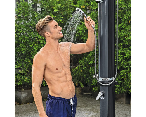 Mann unter Gartendusche mit Handbrause