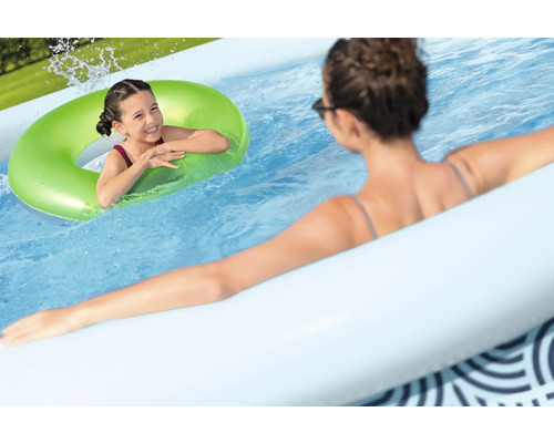 Kind mit grünem Schwimmring in einem aufblasbaren Pool
