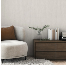 Wohnzimmer mit Sessel, Kommode, Büchern und Vase