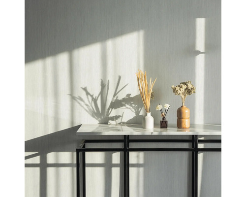 Dekorativer Tisch mit Blumenvasen und Duftspender im hellen Raum.