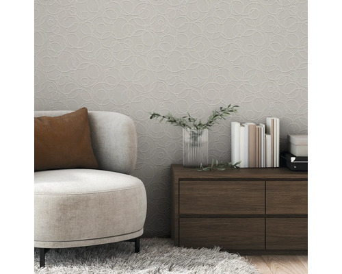 Wohnzimmer mit beigem Sessel, Kommode und gemusterter Tapete