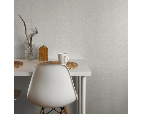 Szene mit einer weißen Tapete, einem Tisch, einem Stuhl, einer Tasse und dekorativen Elementen