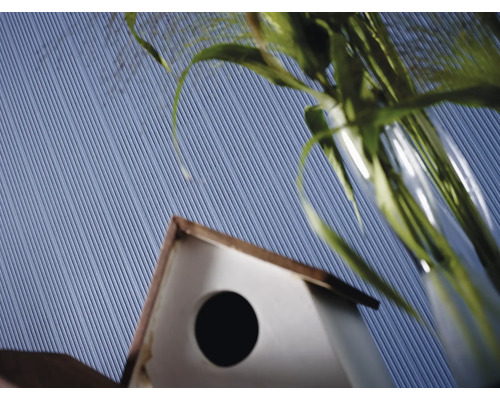 Dekoratives Arrangement mit einem Vogelhaus und einer Vase auf einem strukturierten Hintergrund.