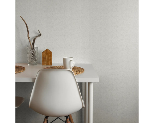 Szene mit Esstisch, Stuhl, Dekoration und gemusterter Tapete.