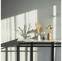 Dekorative Anordnung von getrockneten Blumen und Gräsern auf einem Tisch mit schwarzem Metallgestell