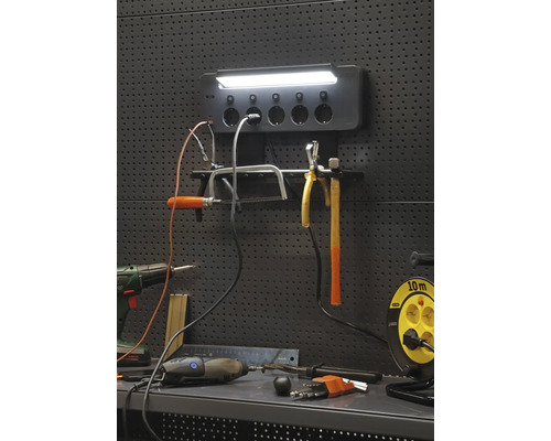 Werkstattwand mit Werkzeugen, Steckdosenleiste und Lampe für Heimwerkerbedarf