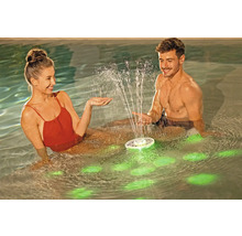 Ein Paar genießt einen schwimmenden Poolbrunnen mit Beleuchtung im Wasser.