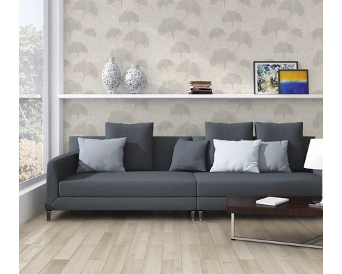 Wohnzimmer mit grauer Couch, Bücherregal und dekorativer Tapete mit Pflanzenmotiven.