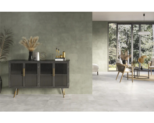 Heller, freundlicher Raum mit Fliesenboden, Kommode und Sitzgruppe.