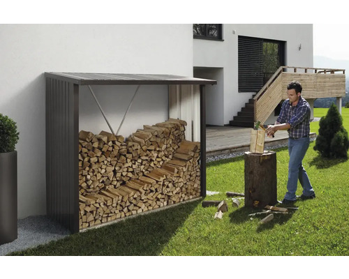 Holzlager mit Brennholz und Mann beim Holzspalten im Garten.