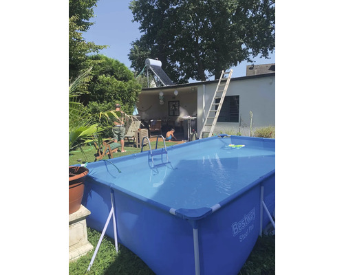 Aufblasbarer Pool im Garten mit Leiter und Wasserspielzeug.