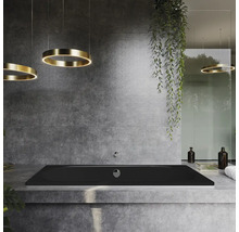 Badezimmer mit schwarzer Badewanne, runden Deckenleuchten und Betonwand