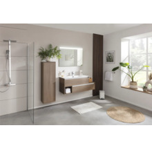 Helles Badezimmer mit Dusche, Waschtisch mit Spiegel, Hochschrank und dekorativen Elementen.